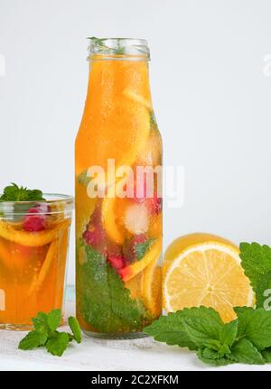 Boisson rafraîchissante de l'été avec de la limonade citron, canneberge, feuilles de menthe, la chaux dans une bouteille en verre, à côté les ingrédients pour faire un cocktail Banque D'Images