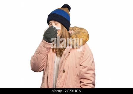 Une jeune femme dans des vêtements d'hiver est maintenant un mouchoir et le nez d'un coup Banque D'Images