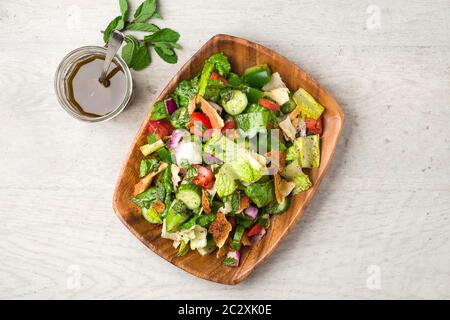 Vue sur le plateau plat de la salade Fattoush. L'ingrédient clé de ce plat du Moyen-Orient est le pain pita grillé qui est mélangé avec des légumes sains Banque D'Images