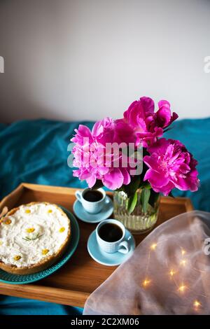 Beau matin cheesecake vanille, café, tasses bleu, rose de pivoines dans un vase en verre Banque D'Images