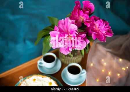 Beau matin cheesecake vanille, café, tasses bleu, rose de pivoines dans un vase en verre Banque D'Images