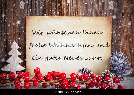 Papier avec texte allemand Frohe Weihnachten und ein gutes Neues signifie Jahr Joyeux Noël et une Heureuse Nouvelle Année. Décoration de Noël en bois et Backgrou Banque D'Images