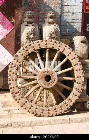 Image montrant une roue en bois cloutée en métal antique et quelques sculptures et meubles devant un magasin d'antiquités dans la ville antique de Zhou Cun, Banque D'Images