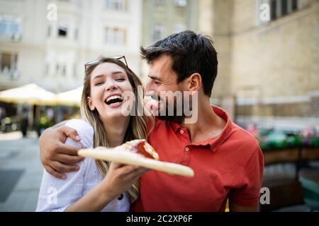 Un couple heureux qui mange de la pizza pendant ses vacances Banque D'Images