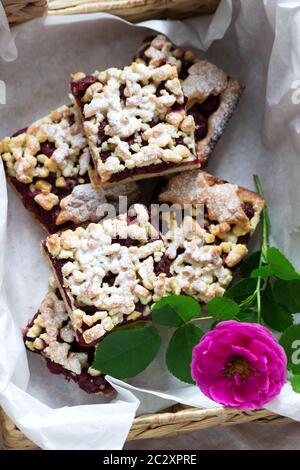 Gâteau sucré avec arènes de rose de cerise et streusel sur fond de bois. Style rustique. Banque D'Images