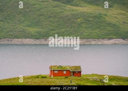 Maison d'été en bois norvégien surplombant le lac pittoresque, la Norvège, la Scandinavie. Cottage par lac en Rural. Cabane au toit de tourbe sur le lac. T Banque D'Images