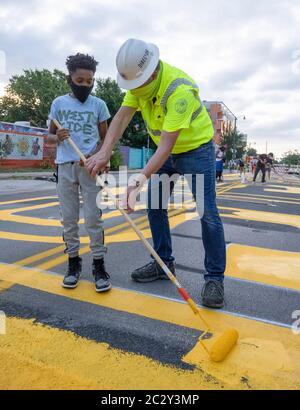 Austin, Texas, États-Unis. 18 juin 2020. Robert Spilar, directeur des transports de la ville d'Austin, enseigne à Tobias jackwoods comment peindre une peinture murale sur le 11ème centre-ville de l'est de St, qui dit « Black Artists Matters » le 18 juin 2020, deux jours après que le groupe ait peint « Black Austin Matters » en grandes lettres jaunes sur Congress Avenue, l'Austin, Rue principale TX. Plusieurs autres villes américaines ont créé des peintures murales commencées lorsque ''Black Lives Matter'' a été peint près de la Maison Blanche à Washington, DC crédit: Bob Daemmrich/ZUMA Wire/Alamy Live News Banque D'Images