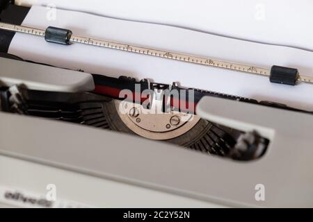 Machine à écrire classique, modèle Olivetti 'Lettera35' conçu en 1972, vue rapprochée sur le tambour où une feuille blanche sans texte est insérée. Banque D'Images