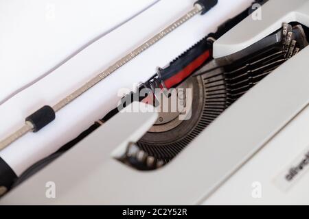 Machine à écrire classique, modèle Olivetti 'Lettera35' conçu en 1972, vue rapprochée sur le tambour où une feuille blanche sans texte est insérée. Banque D'Images