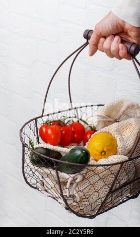 La femme garde le dos avec des légumes frais et des fuits dans des sacs textiles Banque D'Images