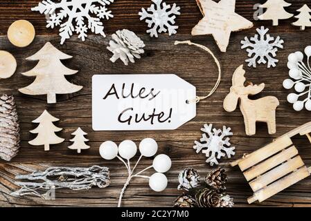 Une étiquette blanche avec texte allemand Alles Gute signifie meilleurs voeux. Image de Noël Décoration comme arbre, traîneau, Star et Fir Cone. Fond de bois Banque D'Images