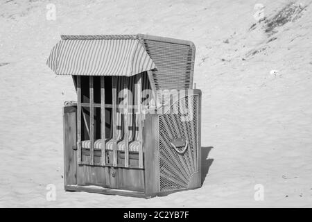 Une chaise de plage fermée se trouve à l'aise sur la plage de la mer Baltique Banque D'Images