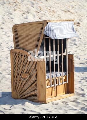 Une chaise de plage fermée se trouve à l'aise sur la plage de la mer Baltique Banque D'Images