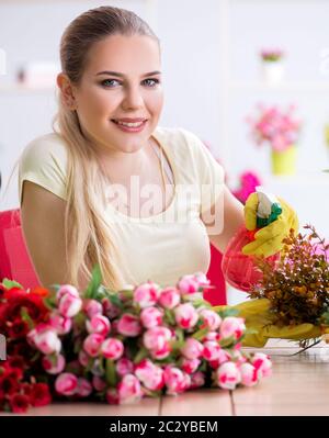 Jeune femme d'arroser les plantes de son jardin Banque D'Images