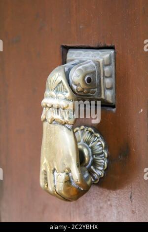 Un knocker de porte métallique en laiton ancien sur une porte en bois Banque D'Images