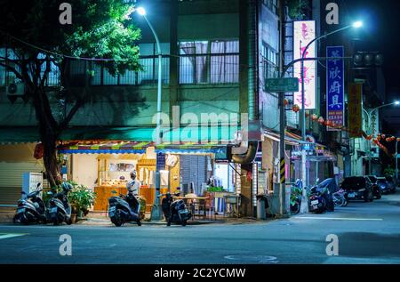 Petit restaurant de coin de rue à Kaohsiung, Taïwan la nuit avec un client qui attend dehors Banque D'Images