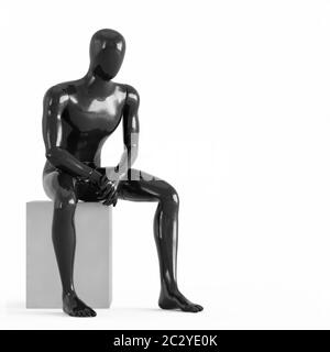 Un mannequin noir sans visage se trouve sur une boîte blanche. Rendu 3D en plastique noir et blanc Banque D'Images