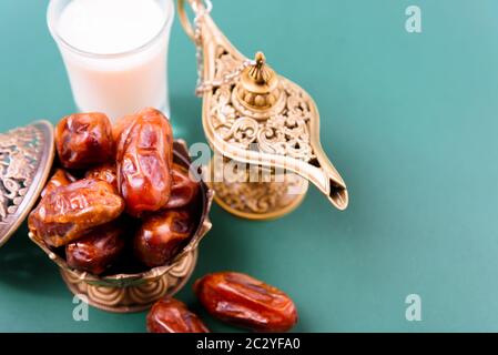 Ramadan, dates dans le bol doré, Le Lait, arabian Aladdin feu de style vintage sur fond vert noir Banque D'Images