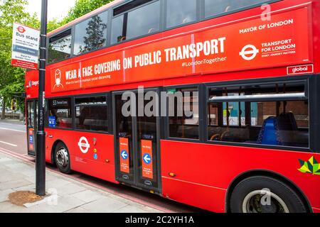 Londres, Royaume-Uni - 17 juin 2020 : un bus rouge de Londres présentant des conseils du gouvernement de porter un revêtement de visage sur les transports publics pour empêcher la propagation de Corona Banque D'Images