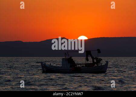 Lever du soleil dans le golfe de Kalloni, et un bateau de pêche est déjà en marche, sur l'île de Lesbos, en Grèce, en Europe. Banque D'Images