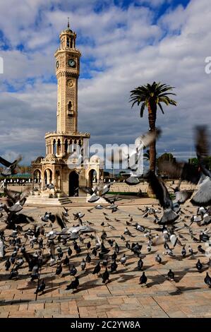 La tour de l'horloge, construite en 1901, située sur la place Konak d'Izmir, avec des pigeons qui volent, est devenue le symbole de la ville. Banque D'Images