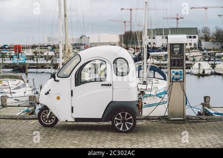 Petite voiture électrique de charge dans la rue en bord de mer à Copenhague, Danemark. Batterie de chargement de voiture électrique. Environnement alternatif e Banque D'Images