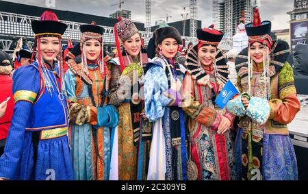 Belles jeunes femmes séjournant dans les costumes traditionnels mongoles de différents groupes ethniques sur la place centrale, dans le DEEL (robe nationale) Banque D'Images