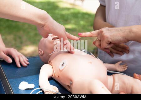 Paramedic performing CPR on baby mannequin de formation Banque D'Images