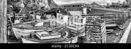 Deux vieux bateaux de pêche et débris qui se trouvent derrière des maisons dans le village de Sisimiut, au Groenland Banque D'Images