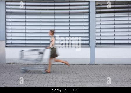 Jolie, jeune femme faisant du shopping à l'épicerie avec un chariot Banque D'Images