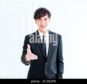 Smiling businessman reaching out pour une poignée de main Banque D'Images