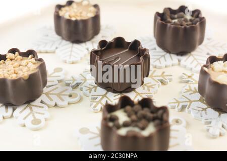 Assortiment de pralines au chocolat avec poudre de cacao sur fond en bois. Tasses de chocolat remplies de praline Banque D'Images