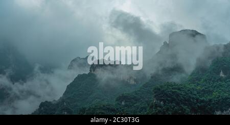 Vue sur la célèbre montagne Tianmen sacrés couverts tôt le matin, le brouillard et la brume, Zhangjiajie, Chine Banque D'Images