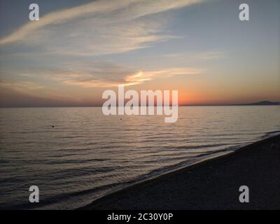 Paysage marin avec ciel bleu et orange et soleil doré. La mer Noire dans la région de Krasnodar. En premier plan-une plage de sable, silhouettes de gens, UM Banque D'Images
