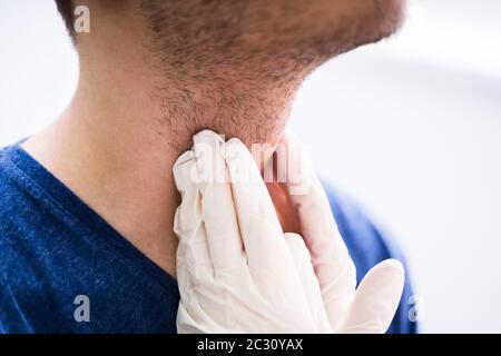Médecin effectuant l'examen physique la palpation de la glande thyroïde Banque D'Images