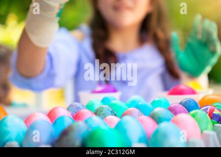 Gros plan photo d'un grand nombre d'oeufs de Pâques colorés, petite fille avec plaisir décorent le symbole traditionnel de Pâques, le plaisir de printemps, des vacances religieuses heureux Banque D'Images