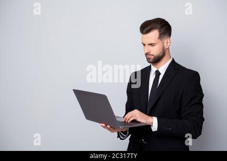 Portrait de l'homme concentré entrepreneur travail sur son ordinateur portable chat avec des partenaires clients regarder démarrage séminaire porter tenue de classe isolée sur la couleur grise Banque D'Images