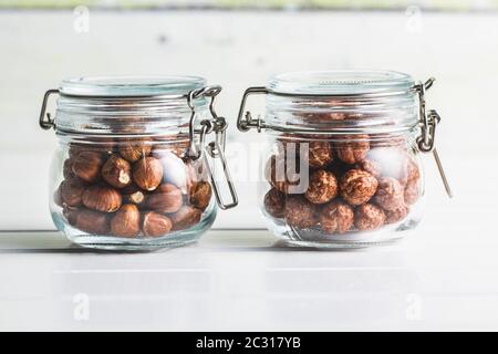 Noisettes avec glaçage au sucre dans le bol sur table blanche. Banque D'Images