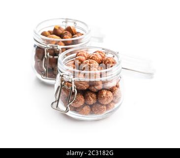 Noisettes avec glaçage au sucre dans un pot isolé sur fond blanc. Banque D'Images