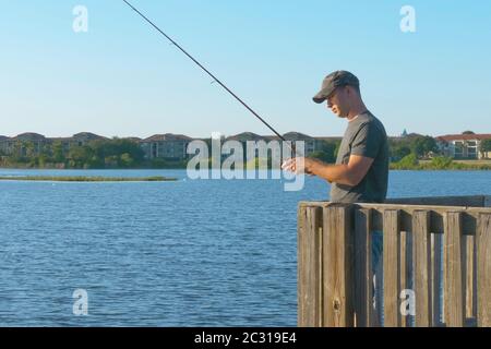 Pêcheur de canne à pêche dans l'eau du lac ou de la rivière. Banque D'Images
