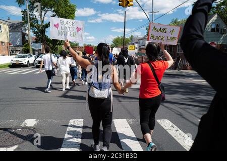 Deux femmes qui se tiennent à la main pour marcher sur Black Lives Matter manifestants défilent à Flushing, à New York, pour protester contre la mort de George Floyd Banque D'Images