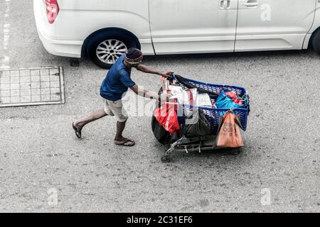 Vue de dessus de l'homme asiatique sans abri poussant le chariot à Kuala Lumpur en Malaisie Banque D'Images