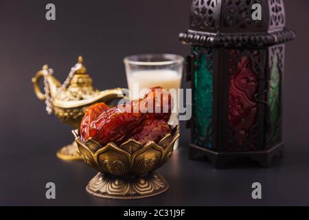 Ramadan Kareem concept alimentaire à jeun, dates de la plaque de bronze, lait, et lanterne Aladdin lampe décoration, eid festival religieux musulman arabe sur un b noir Banque D'Images