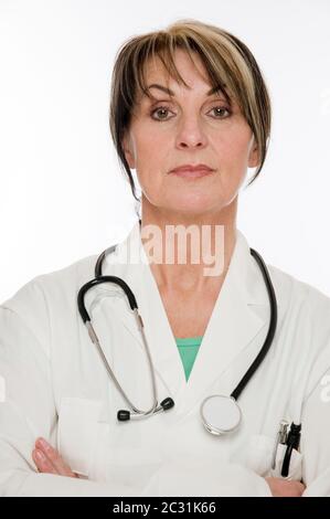 Tête et épaules frontales portrait d'une femme médecin en manteau blanc et stéthoscope autour de son cou isolé contre fond blanc aspect sérieux Banque D'Images