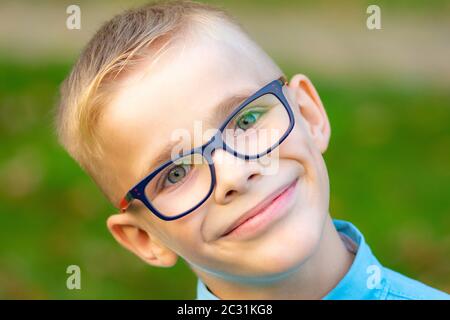 Portrait d'un gros plan d'un jeune garçon joyeux avec des lunettes Banque D'Images
