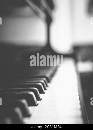 Close-up de touches de piano avec arrière-plan flou. Style vintage photo avec les rayures, la poussière, le grain et la saleté. Une clé dans la mise au point. Banque D'Images