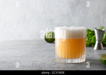 Pisco Sour cocktail - whisky avec jus de lime, sirop de sucre et blanc d'œuf dans le verre. Banque D'Images