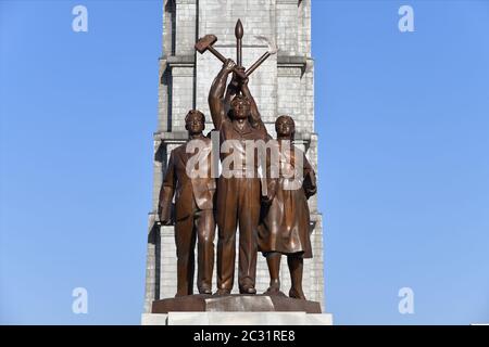 Pyongyang, Corée du Nord - 1er mai 2019 : statue de Juche composée de trois figures idéalisées chacune tenant un outil – un marteau (ouvrier), une faucille (paysan), Banque D'Images