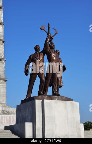 Pyongyang, Corée du Nord - 1er mai 2019 : statue de Juche composée de trois figures idéalisées chacune tenant un outil – un marteau (ouvrier), une faucille (paysan), Banque D'Images