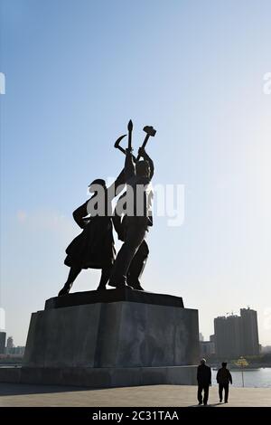 Pyongyang, Corée du Nord - 1er mai 2019 : statue de Juche composée de trois figures idéalisées chacune tenant un outil – un marteau (ouvrier), une faucille (paysan), Banque D'Images